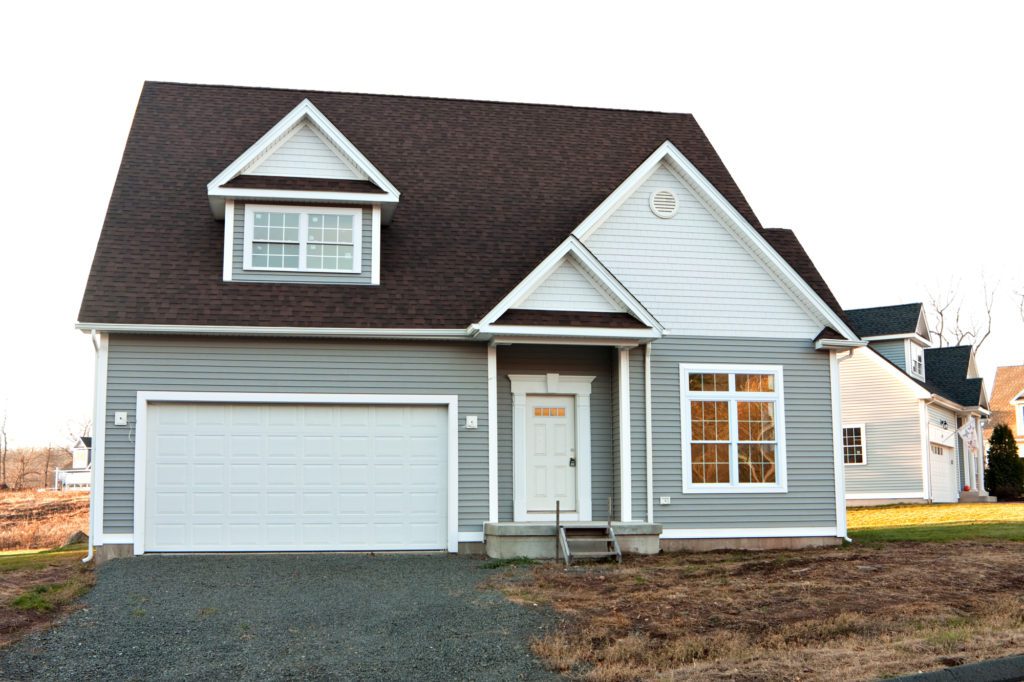 High-contrast color home with light gray siding and dark asphalt roof.