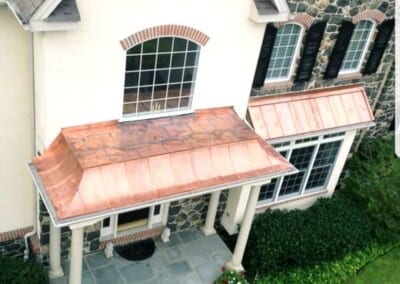 Custom made copper roofs over front entrance and bay window