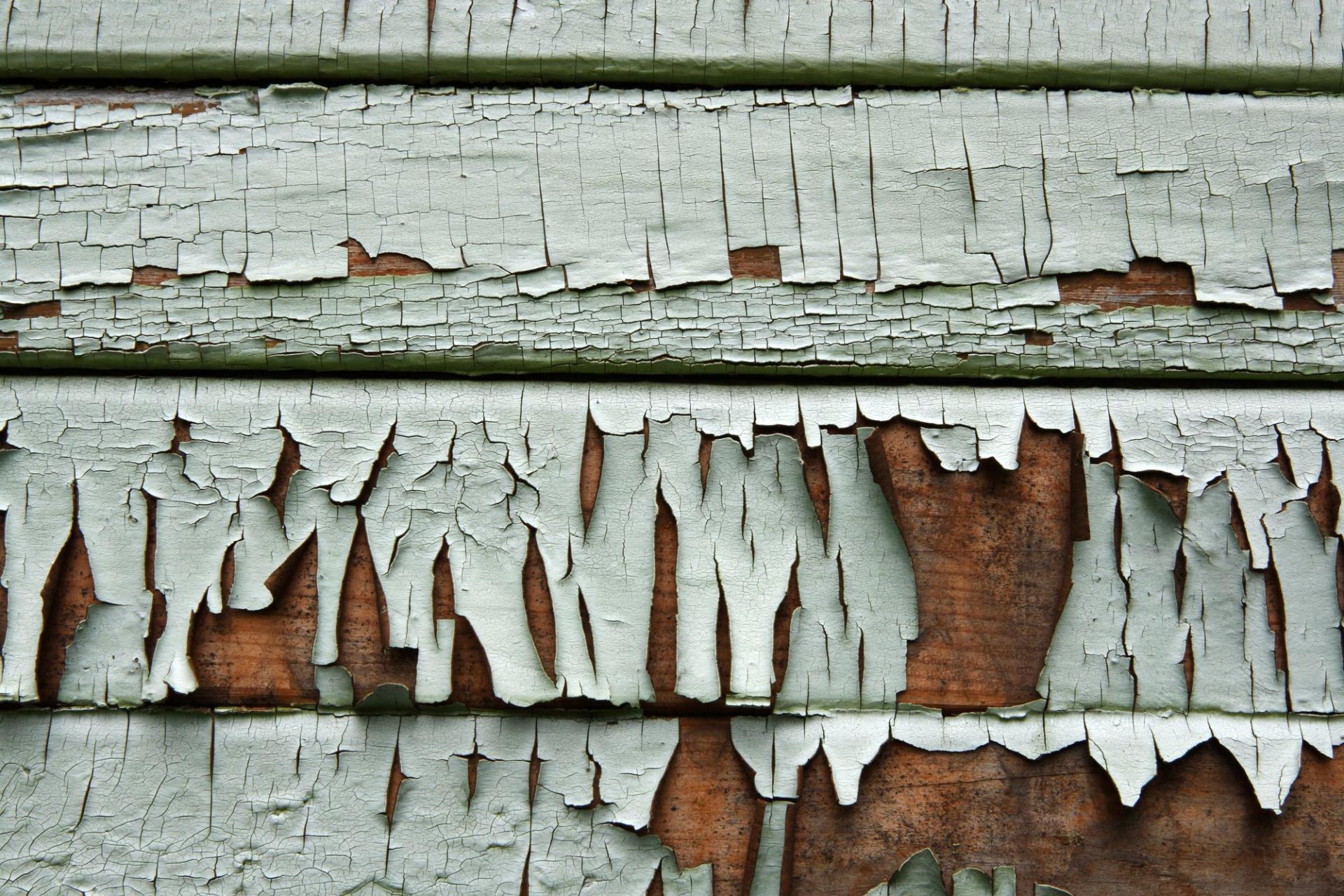 Home siding in need of replacement - clapboard with peeling paint.