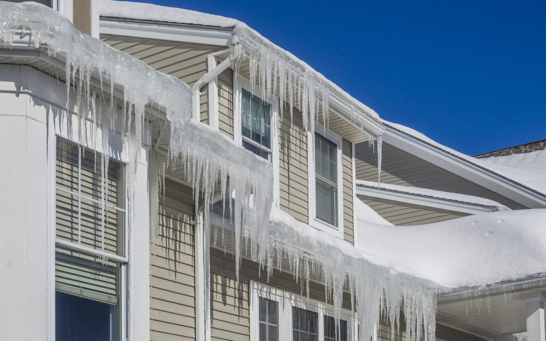 Image of ice dam formed on multiple gutters on the roof of a home