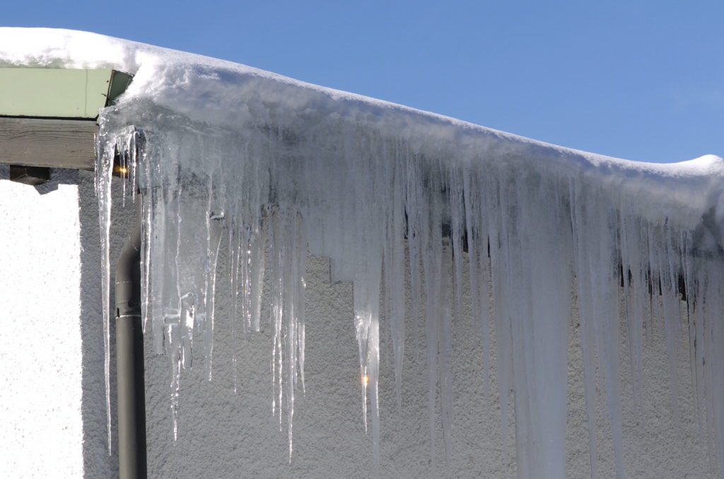 Image of ice dam formed on gutters on the roof of a home