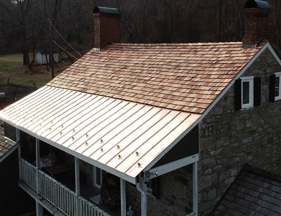 Image of a roof installed with both copper and cedar shake shingles - by Alte Exteriors