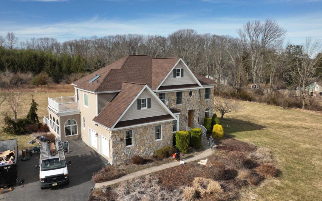 Image of a large New Jersey home with a new brown-tiled roof installed by Alte Exteriors.