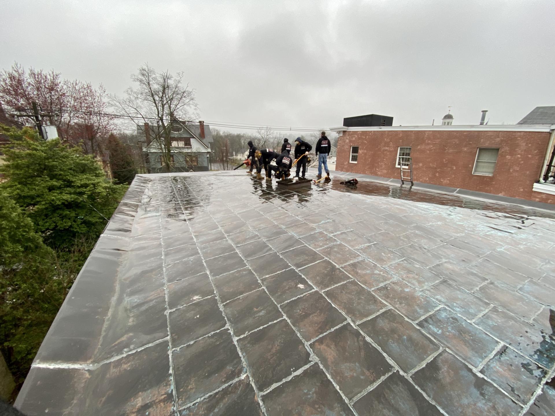 Image of the Alte Exteriors LLC team installing a flat roof.